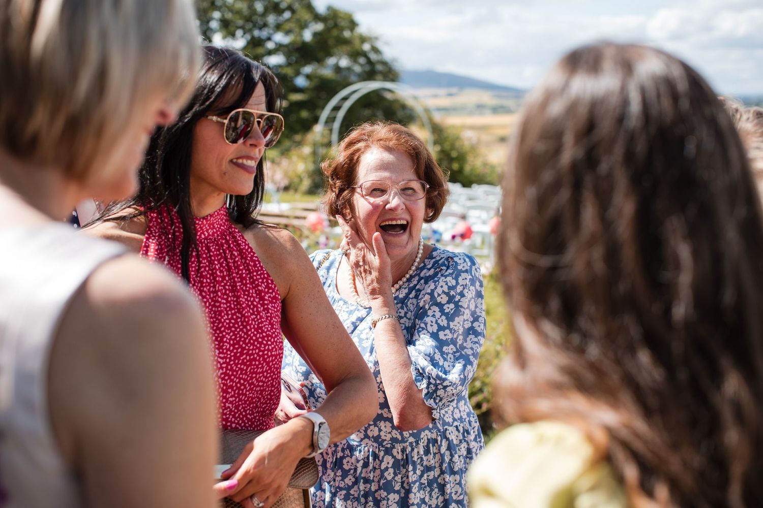 Wedding guests enjoying an outdoor celebration on a sunny summer day.