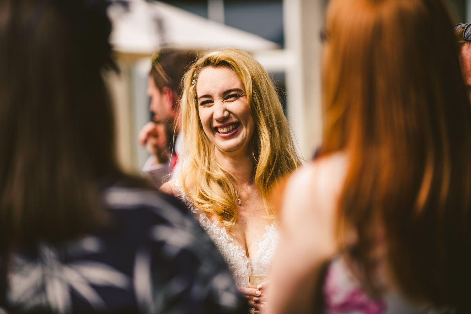 A group of guests sharing laughter and conversation during an elegant wedding celebration.