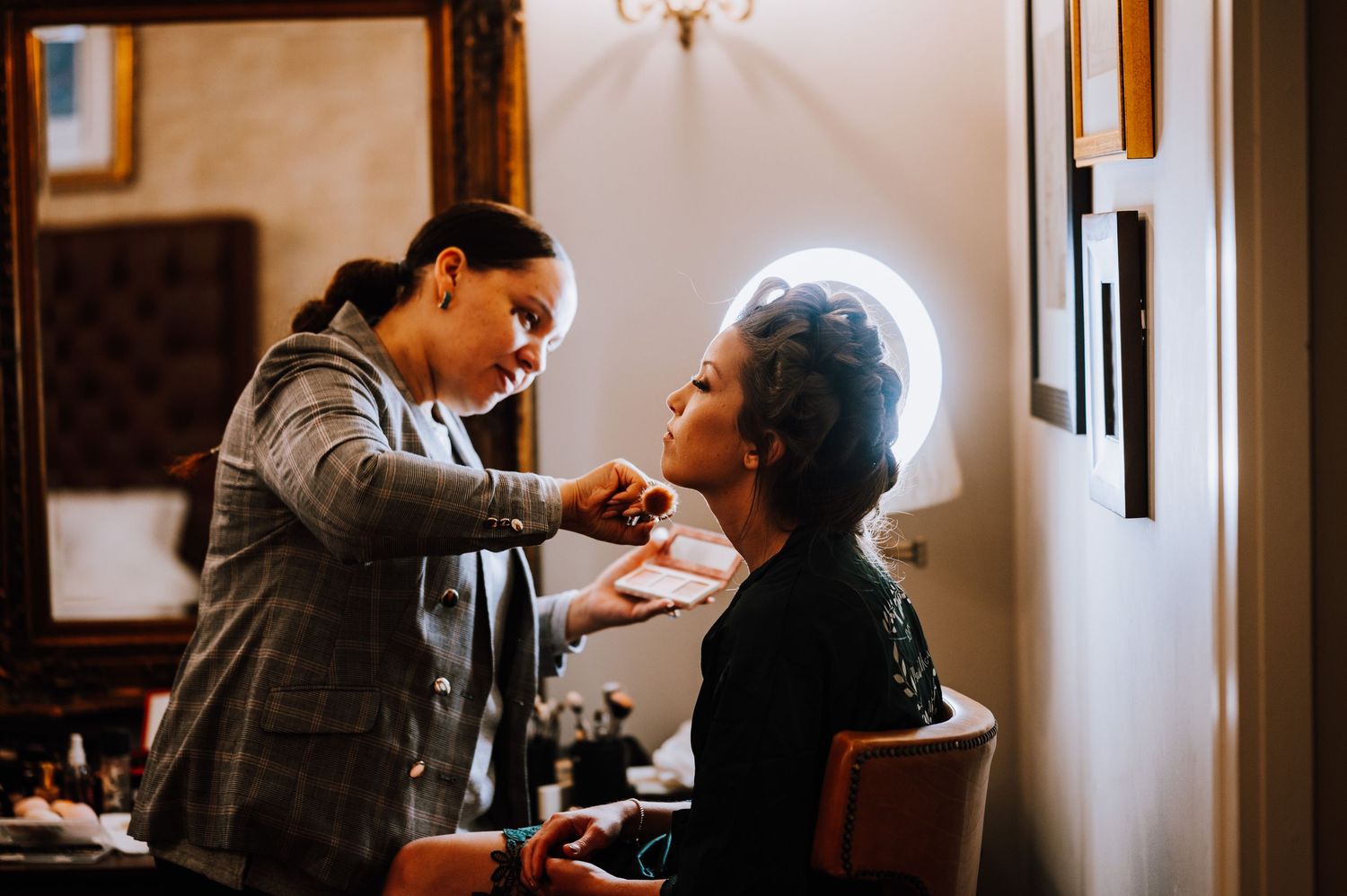 A styling session in progress as makeup is being applied in an elegant interior setting.