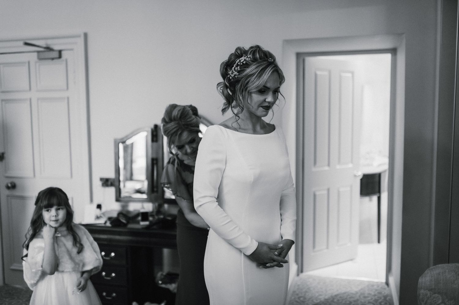 Elegant bridal preparation scene in a bright white room.