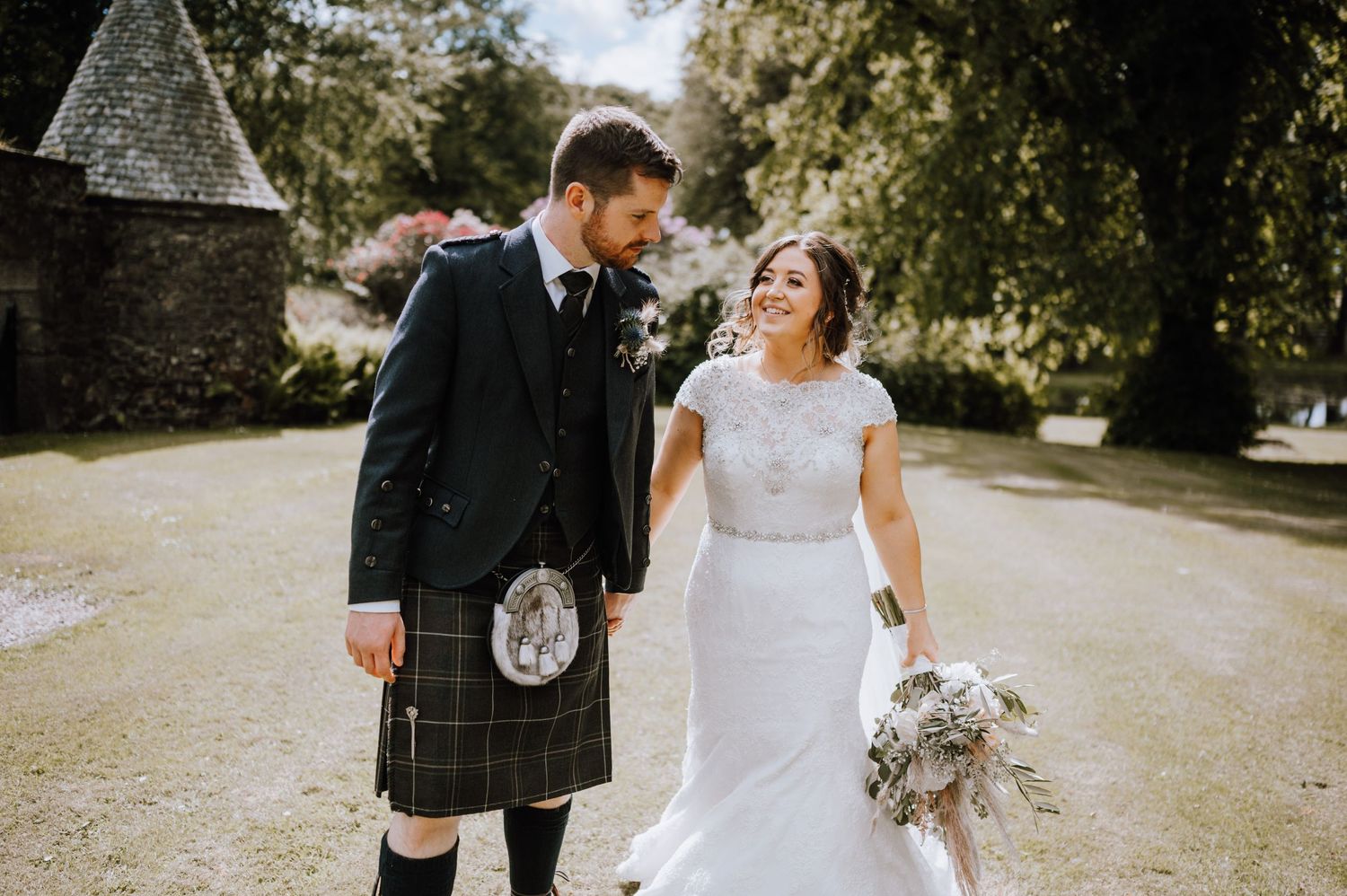 Couple shares joyful moment on path during Scottish wedding.