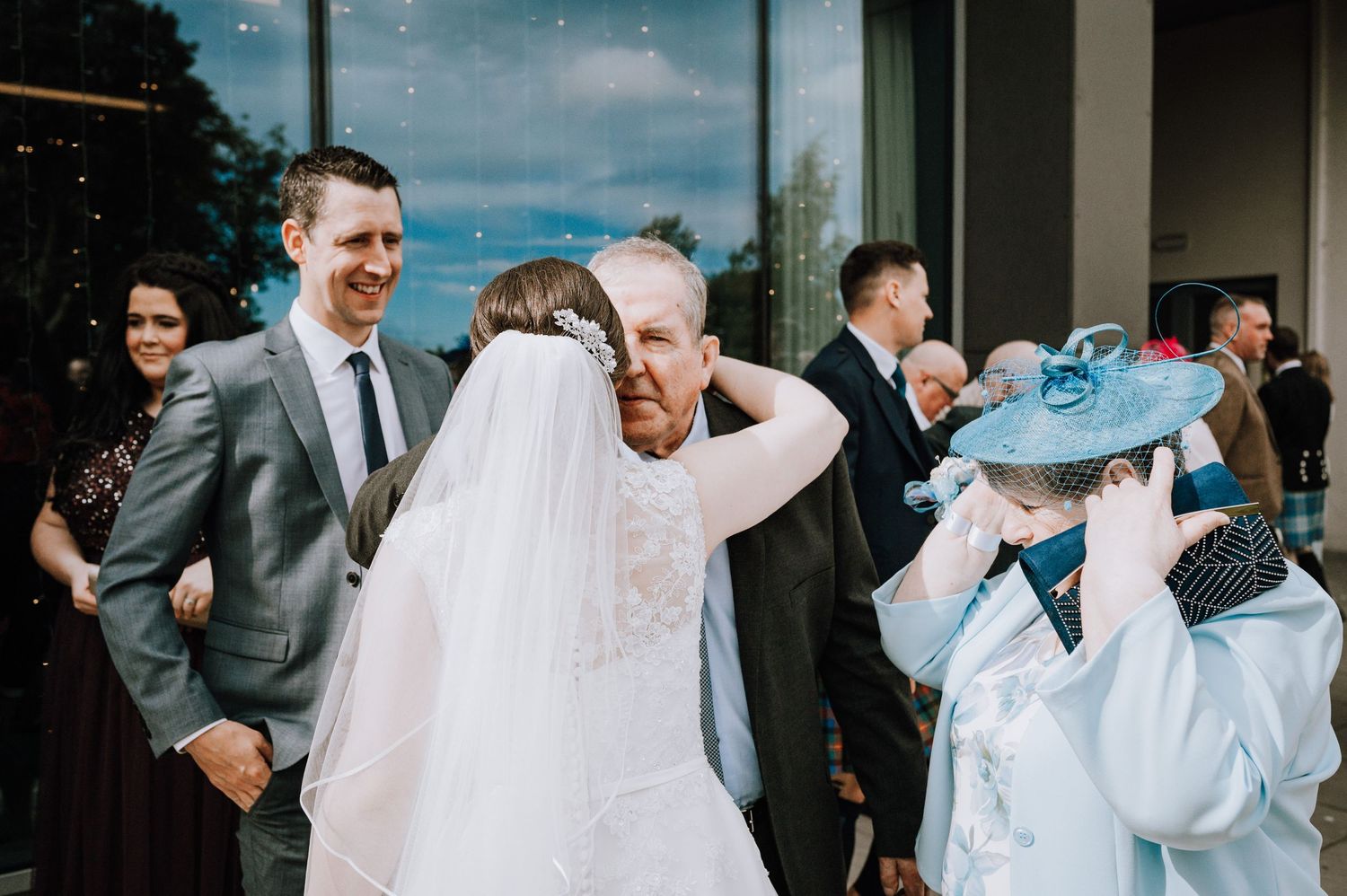 Wedding guests share emotional moments outside during the celebration.