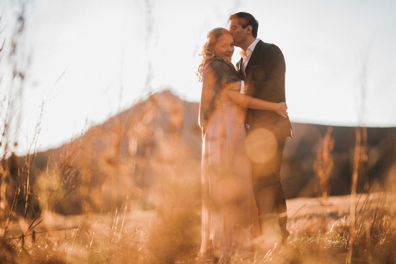 A dreamy sunset portrait with bokeh effects and mountains in the background.