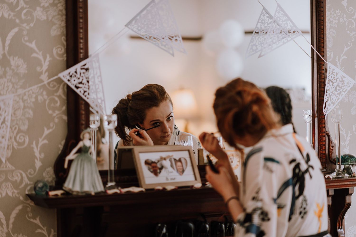 Getting ready scene with vintage vanity mirror and wedding preparations.