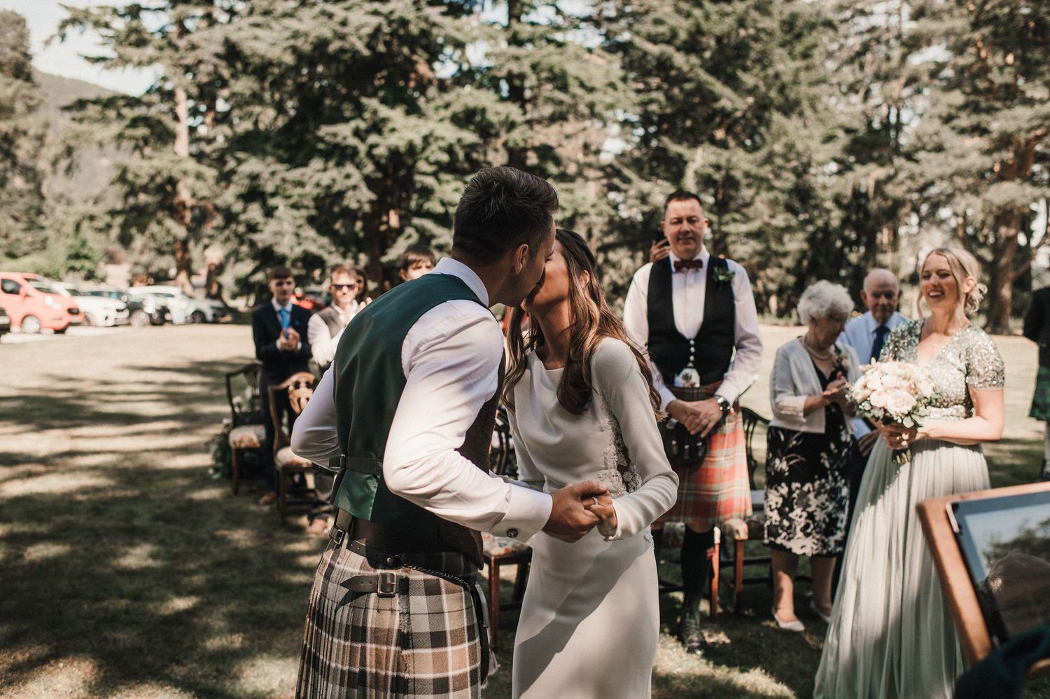 A tender moment between newlyweds during their outdoor forest wedding ceremony.