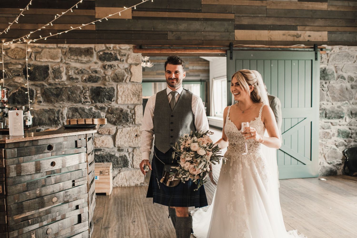 Wedding ceremony in rustic stone venue with string lights and wooden accents.