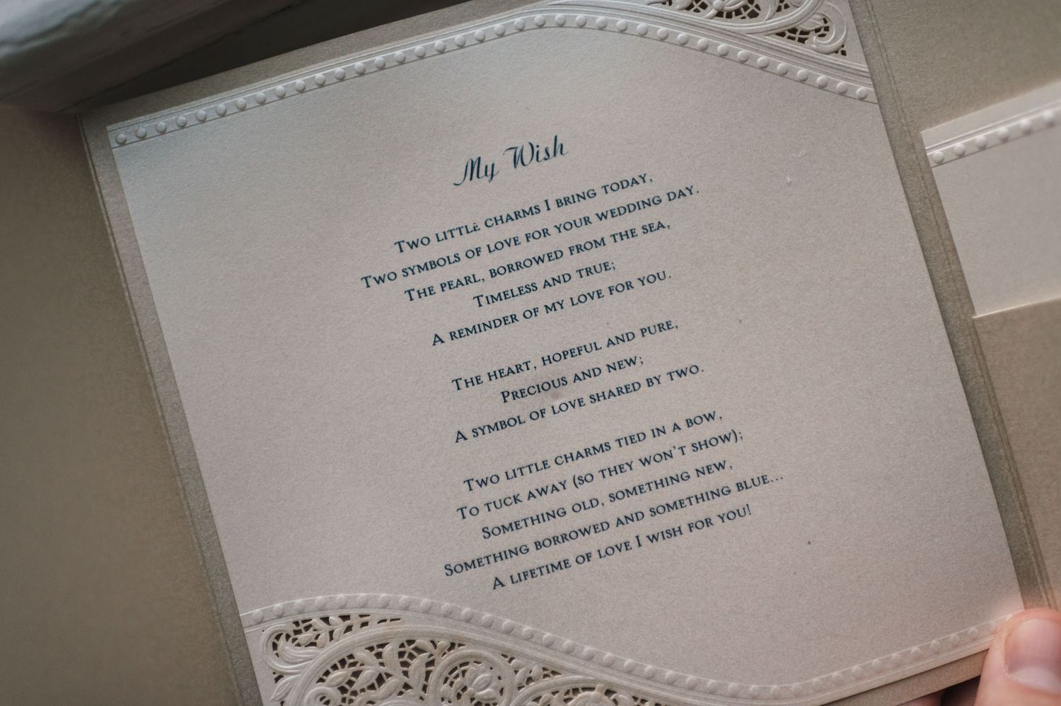 A close-up of printed wedding vows on embossed paper with decorative borders.