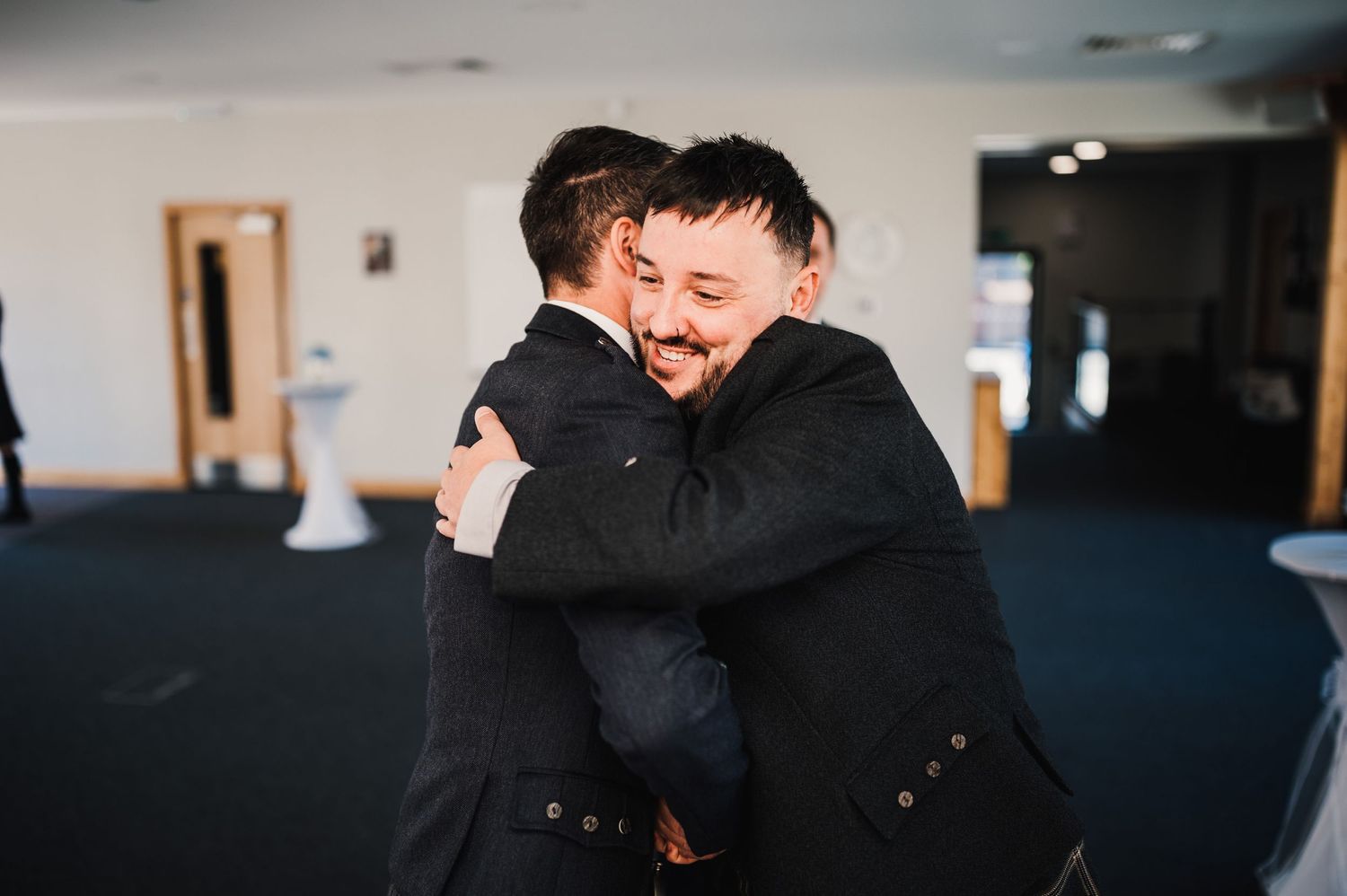 Two guests share an emotional embrace during a wedding celebration.