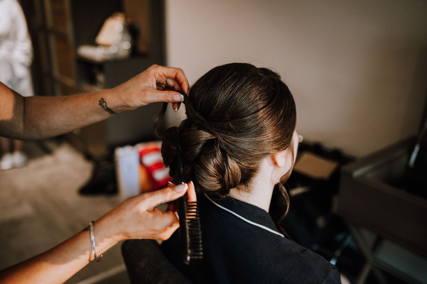 Close up of hairstyling preparation with hands working on elegant updo.