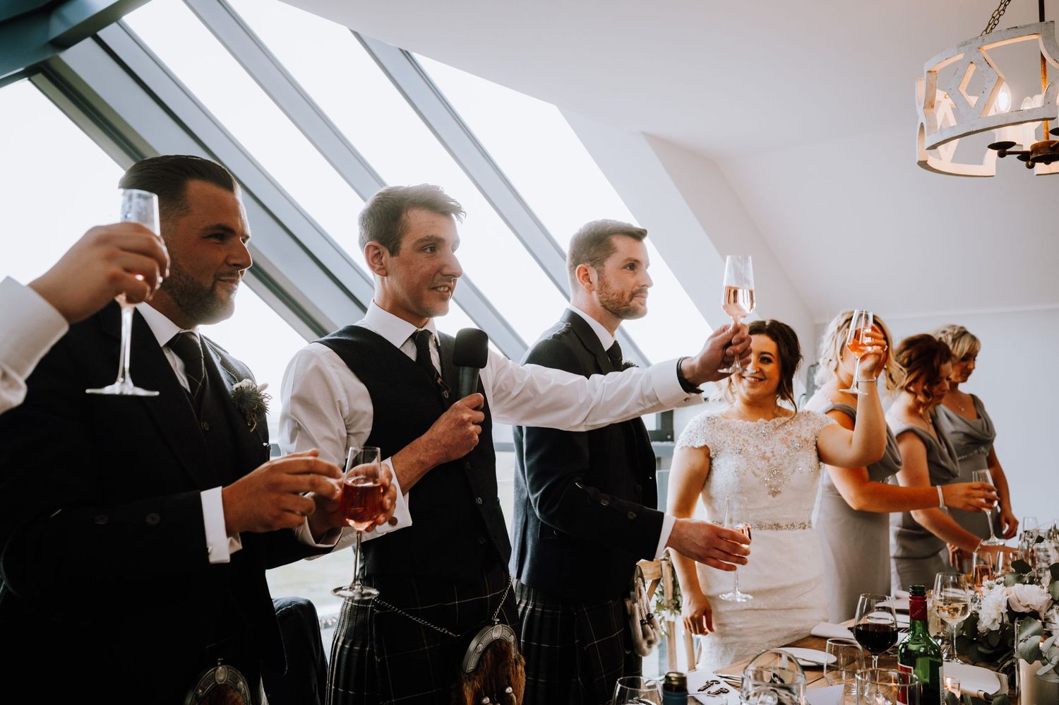 Wedding party members raise their glasses for a celebratory toast.