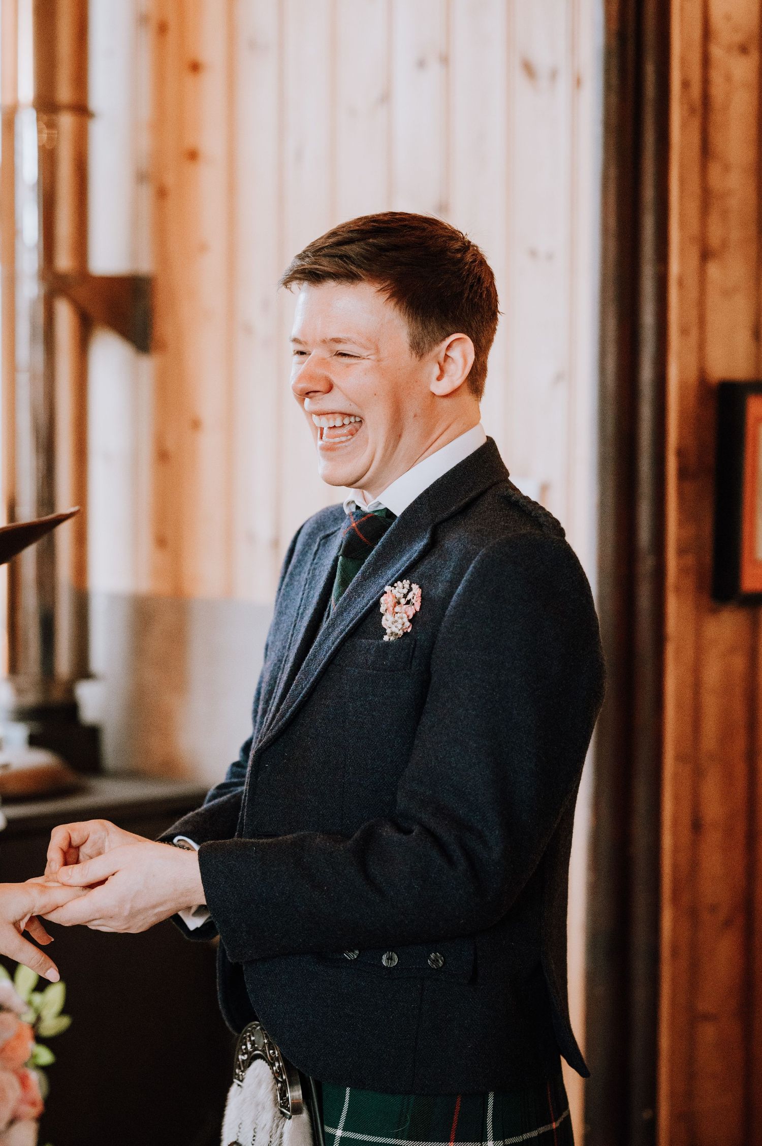 Joyful reaction during a Scottish wedding ceremony wearing traditional formal attire.
