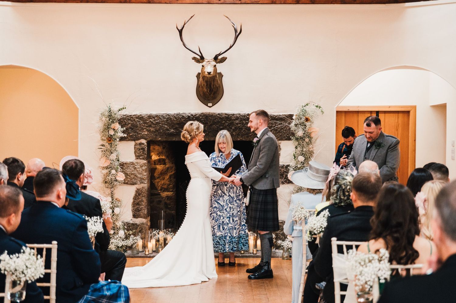 Wedding ceremony venue decorated with antler decor and floral arrangements.