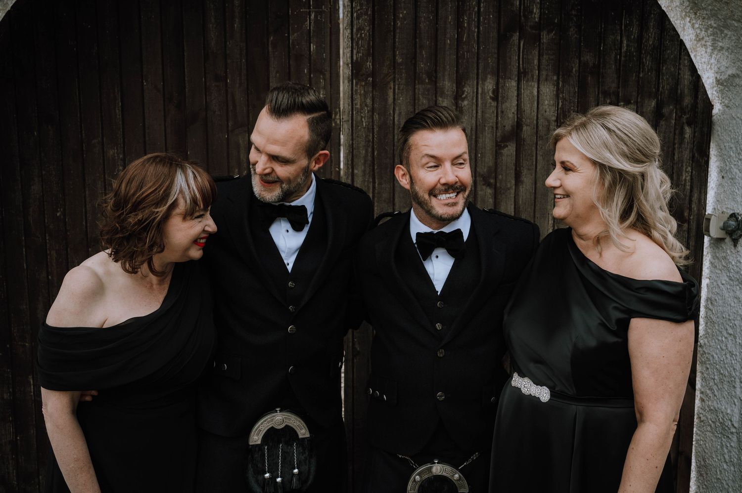 Logie House Wedding Photography. Elegant wedding party in black formal wear posing together outdoors.