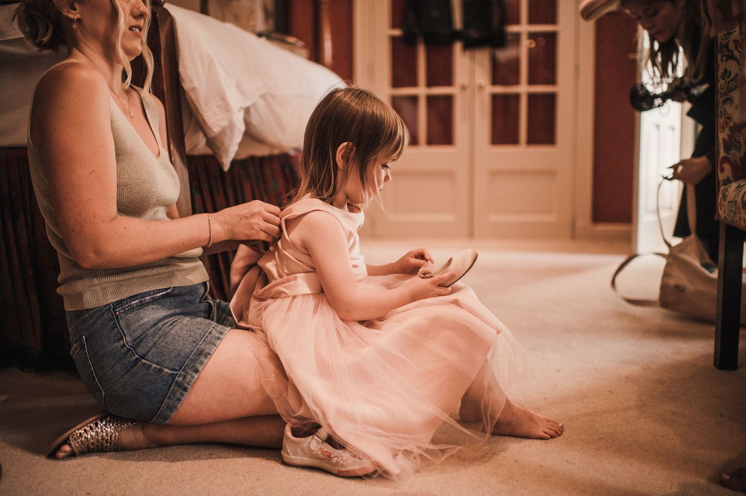 A peaceful scene on a carpeted floor showing gentle interaction in casual attire.