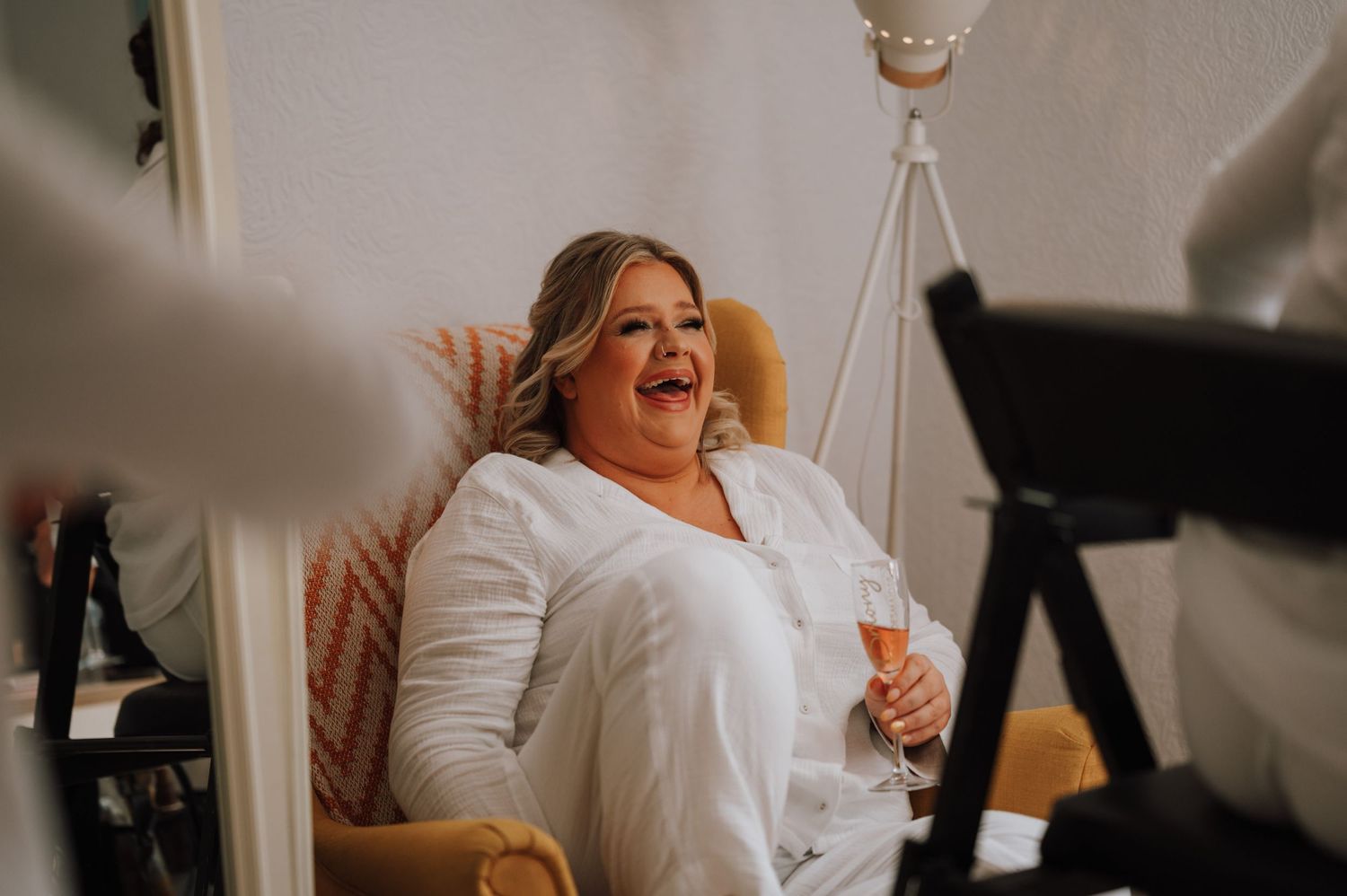 A joyful moment of laughter in a brightly lit room with someone wearing a white button-up shirt.