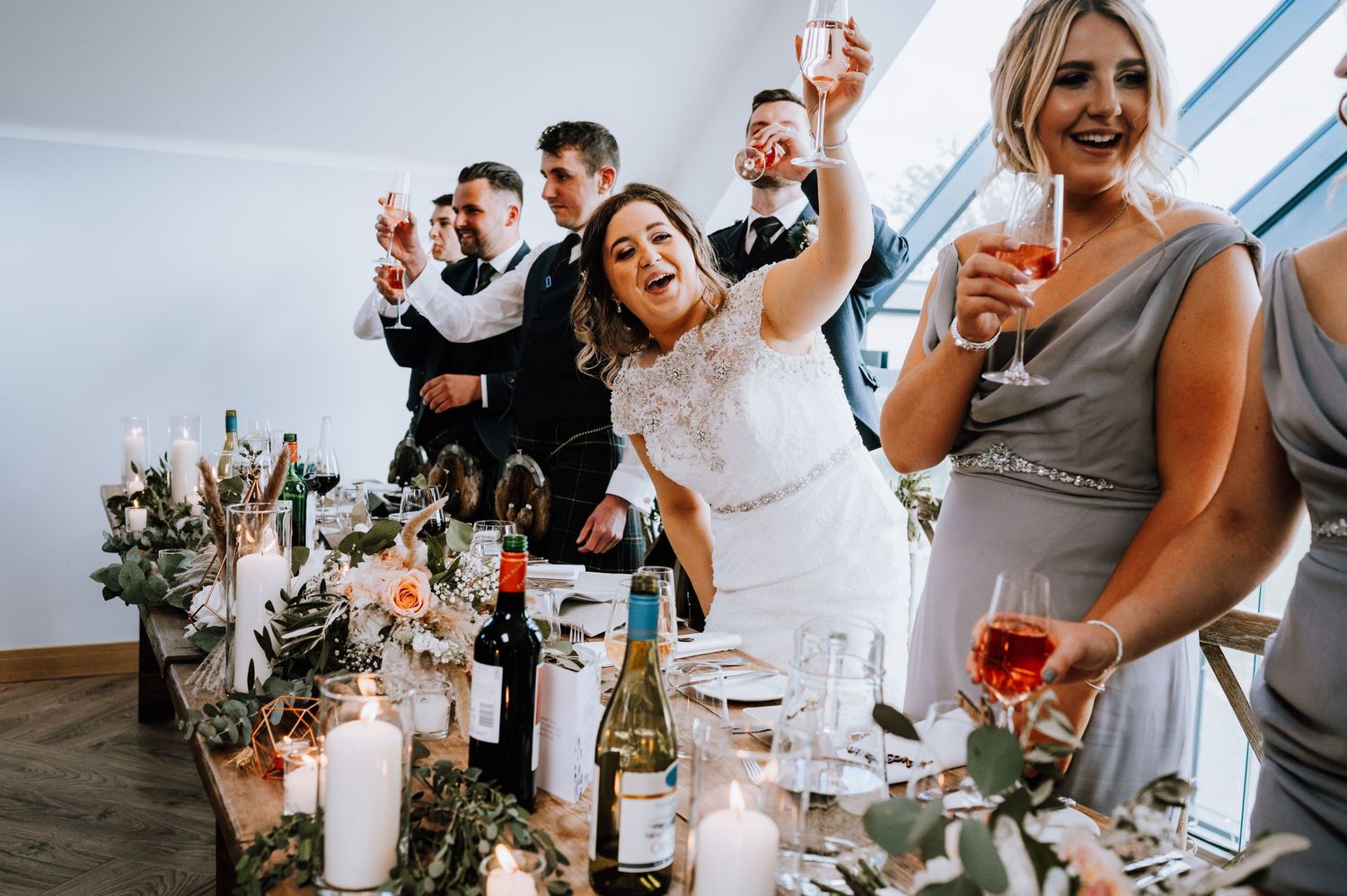 Wedding party raising glasses for a toast during reception celebration.