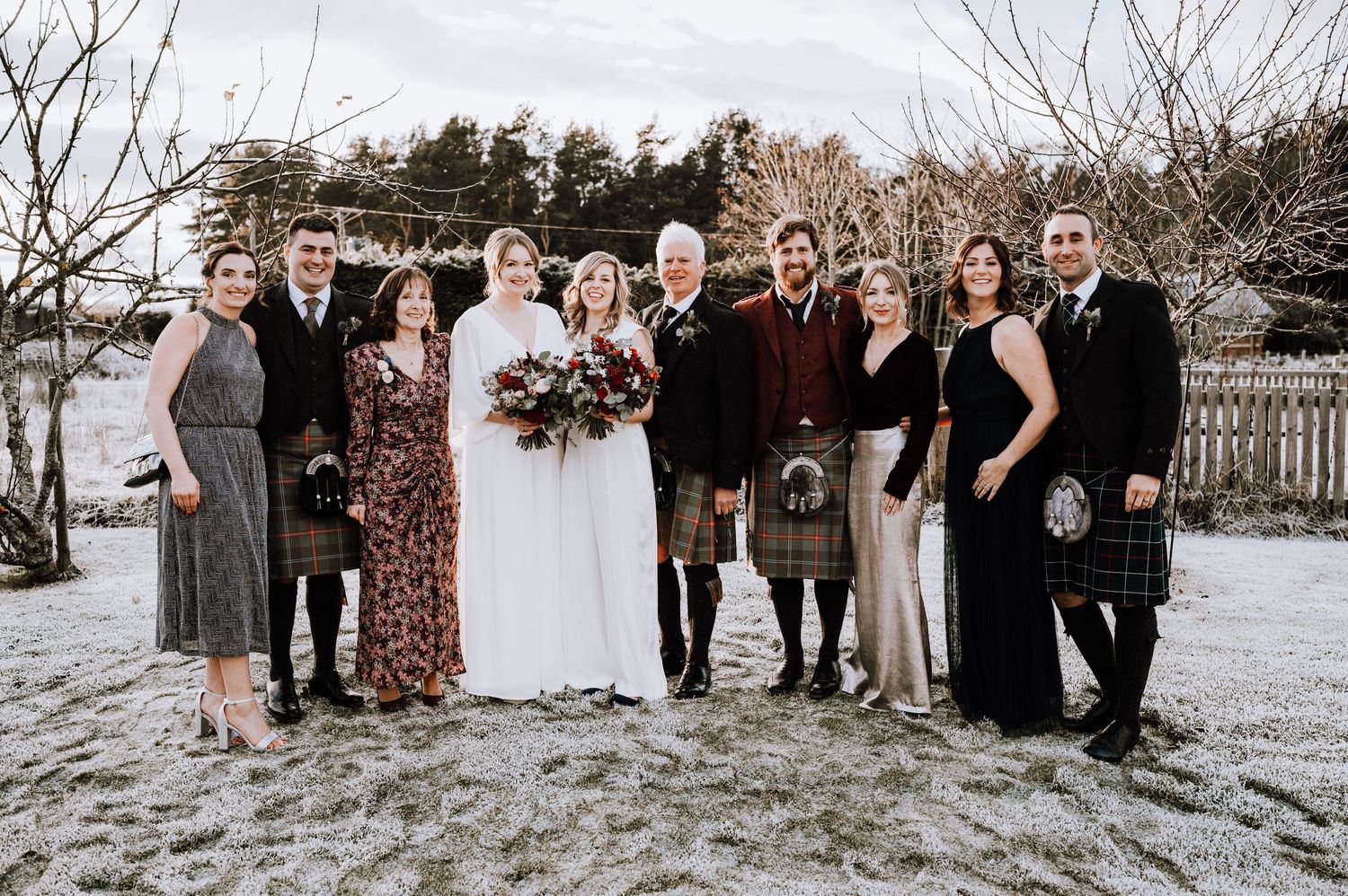 Same Sex Wedding Photography. Wedding party poses for formal group photo in winter with mix of traditional and Scottish formal wear.