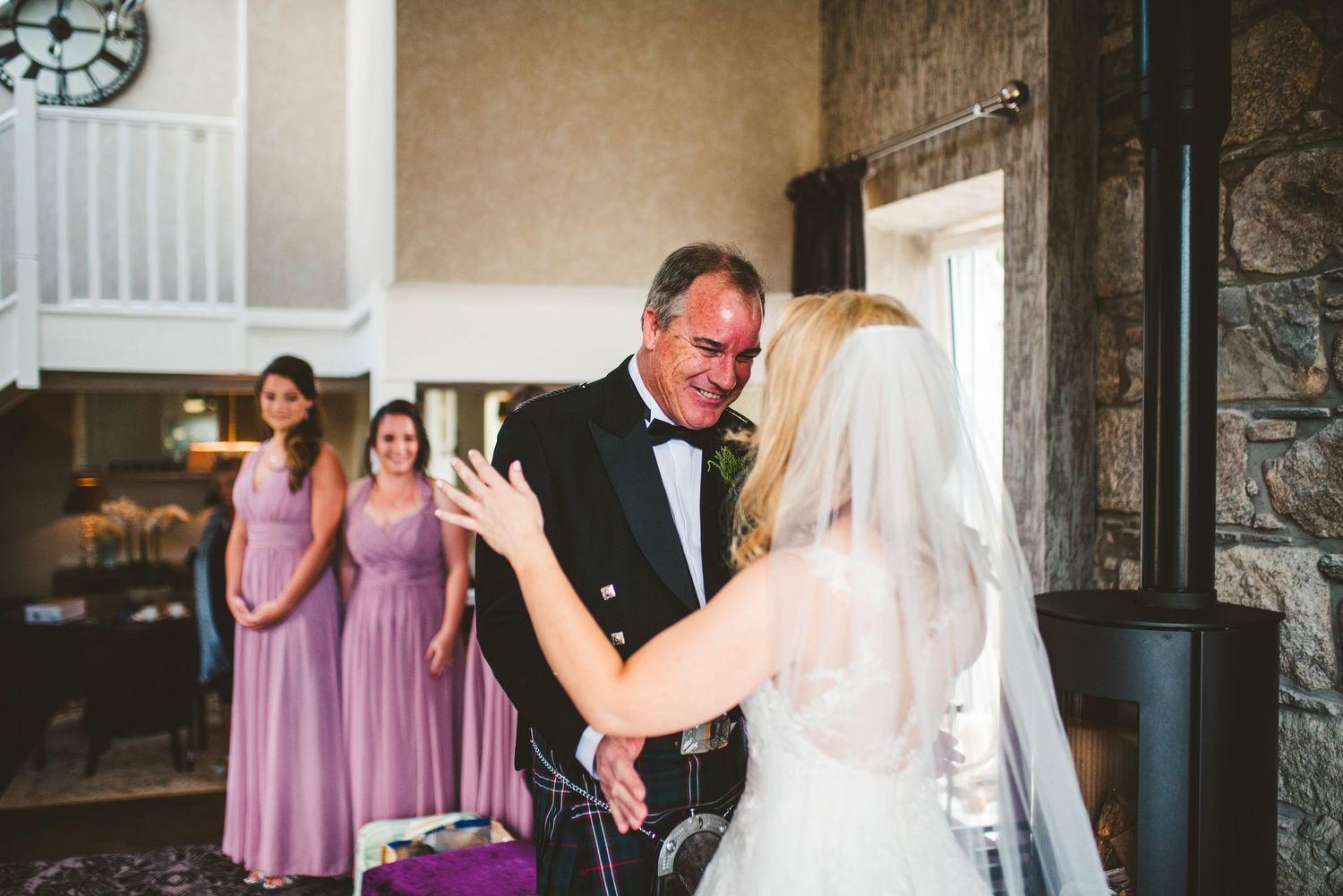 Wedding ceremony guests gather in an elegant indoor venue with stone walls.
