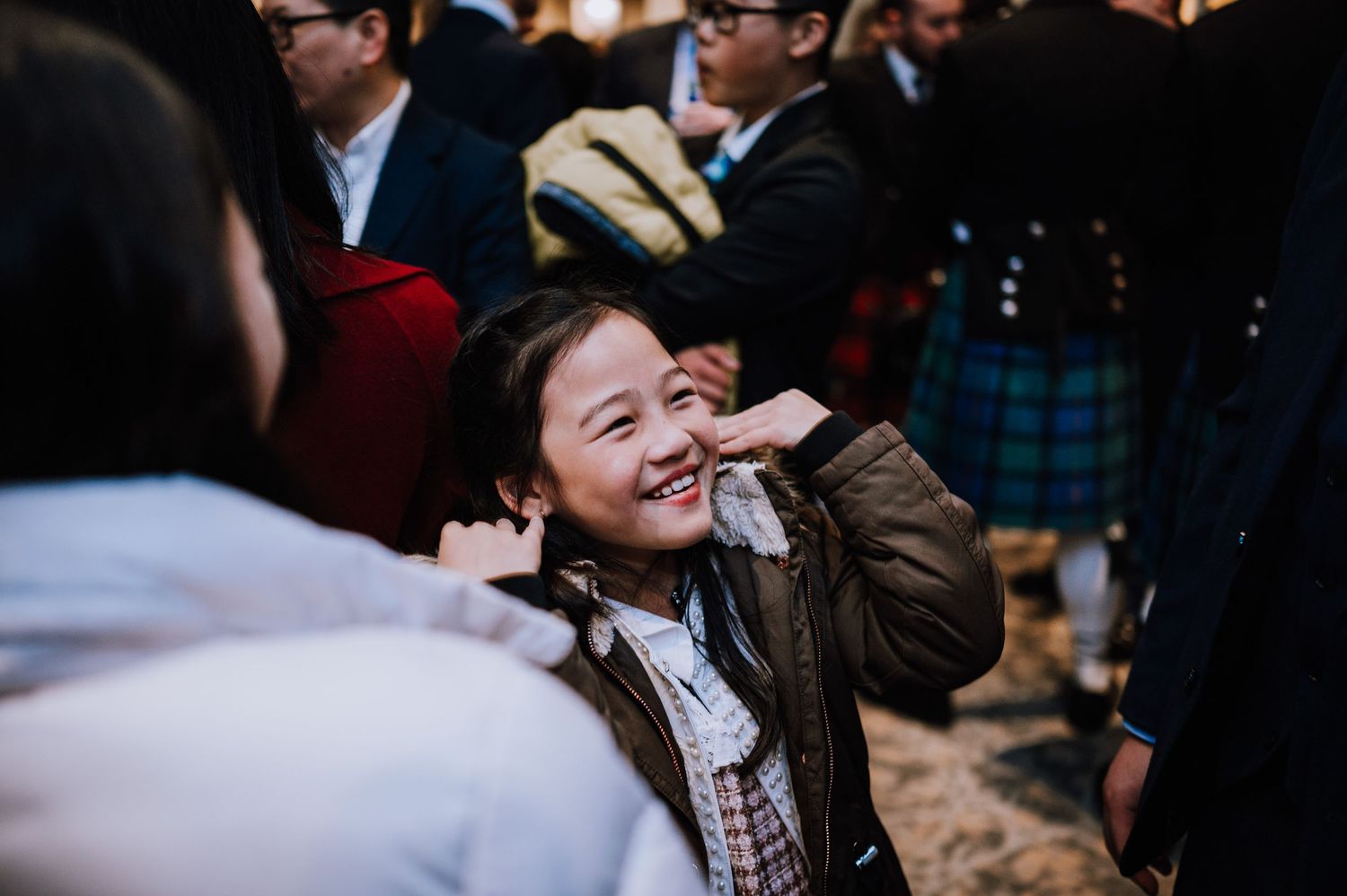 A candid moment captures genuine laughter during a wedding celebration indoors.