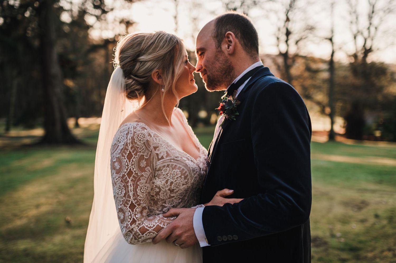 Intimate wedding moment captured during golden hour in garden setting.