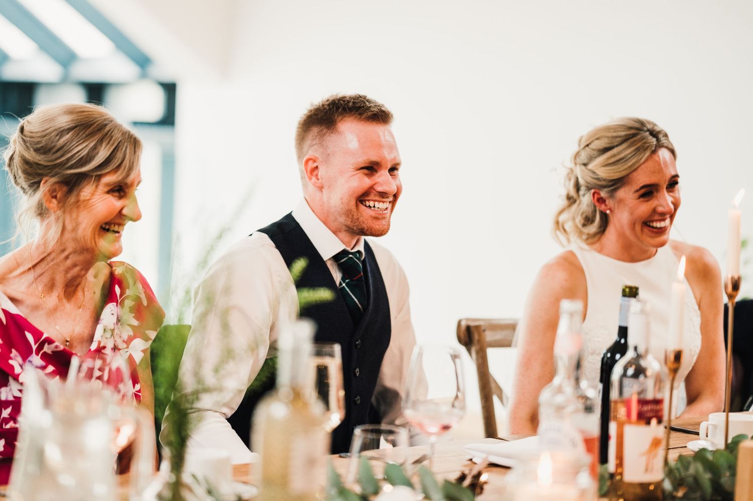 Wedding party shares a joyful moment during reception dinner.