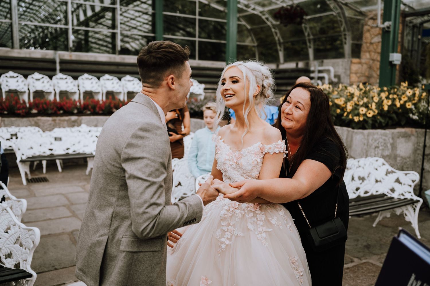 A joyful moment captured during a greenhouse wedding ceremony.