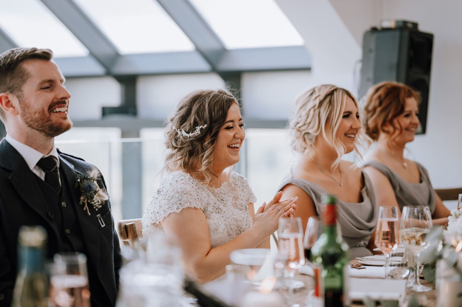 Wedding party members share laughs during reception dinner festivities.