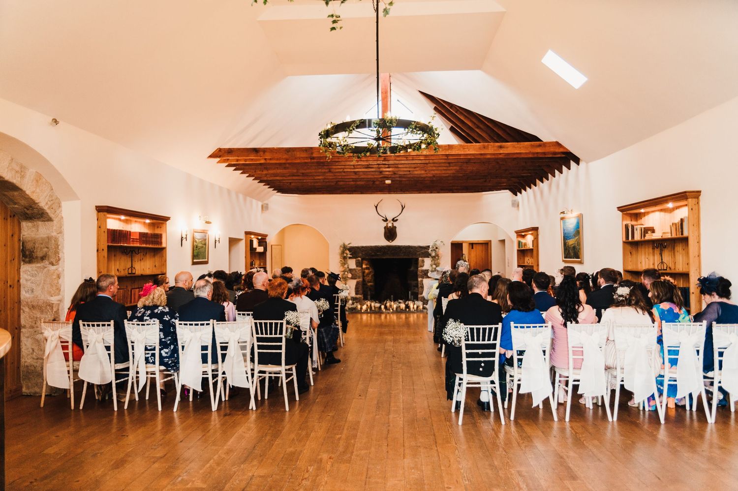 Panoramic view of a wedding reception venue with white chairs and elegant table settings.