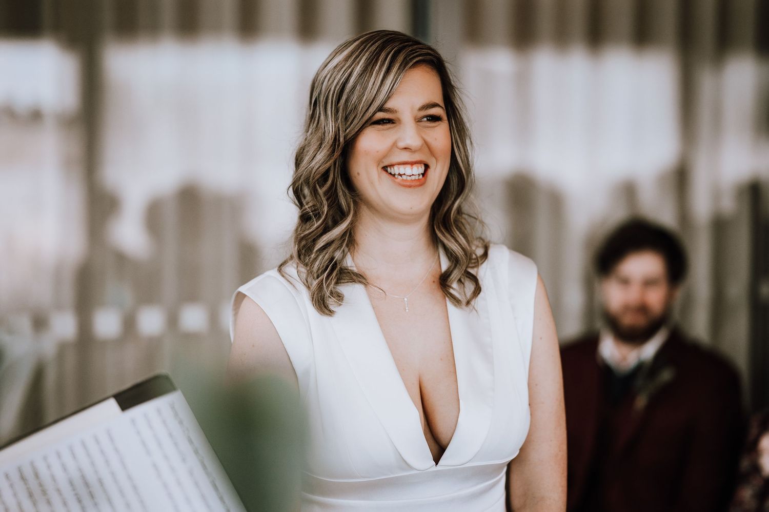 Same Sex Wedding Photography. Wedding preparations in bright indoor space with white decor.