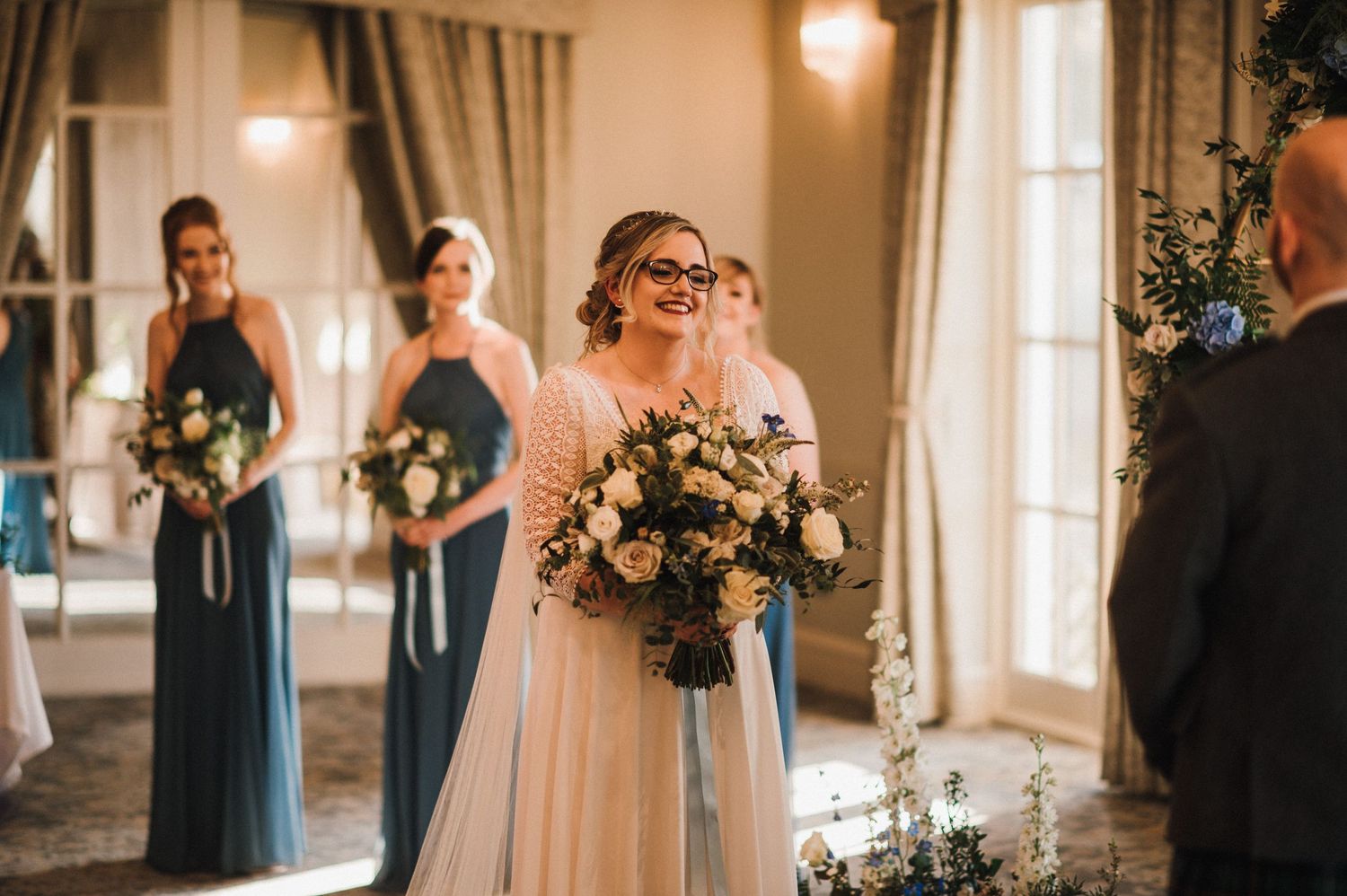 Indoor wedding ceremony with elegant floral arrangements and soft natural lighting.