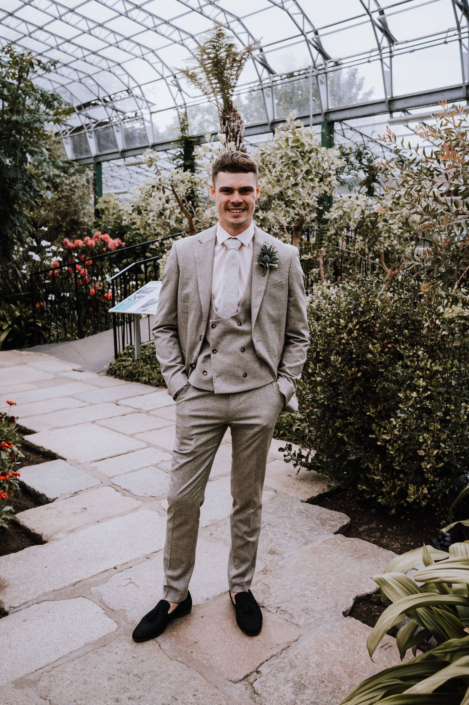 Conservatory wedding photo featuring formal attire and botanical garden backdrop.