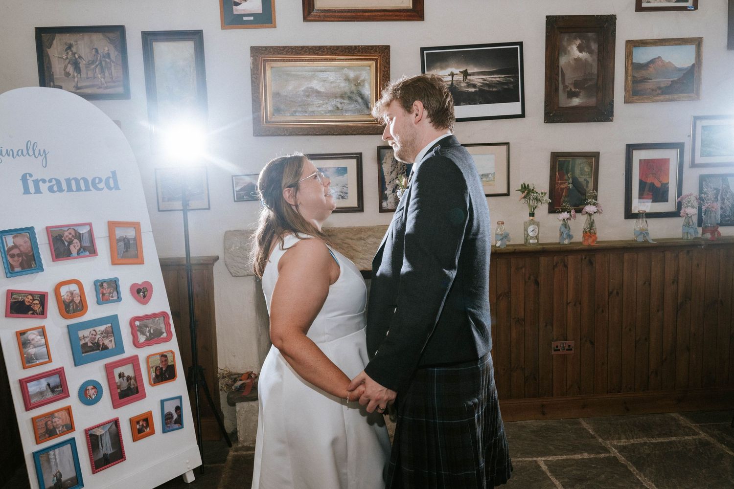 Wedding venue interior showing wall gallery of framed photographs and rustic decor.
