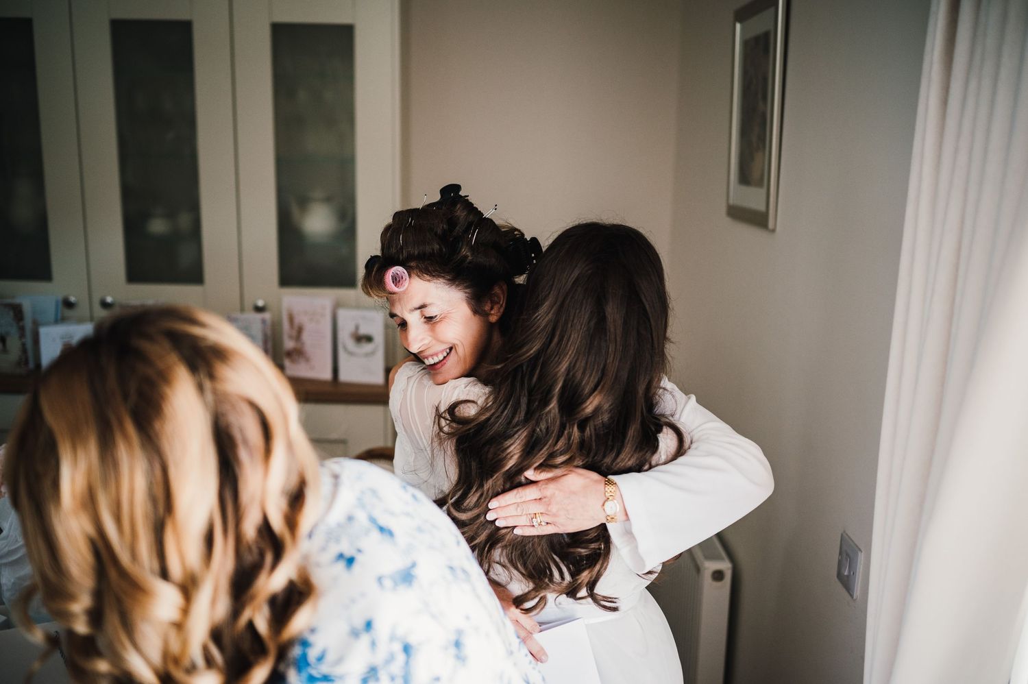 Warm embrace shared between people during an emotional wedding preparation moment.