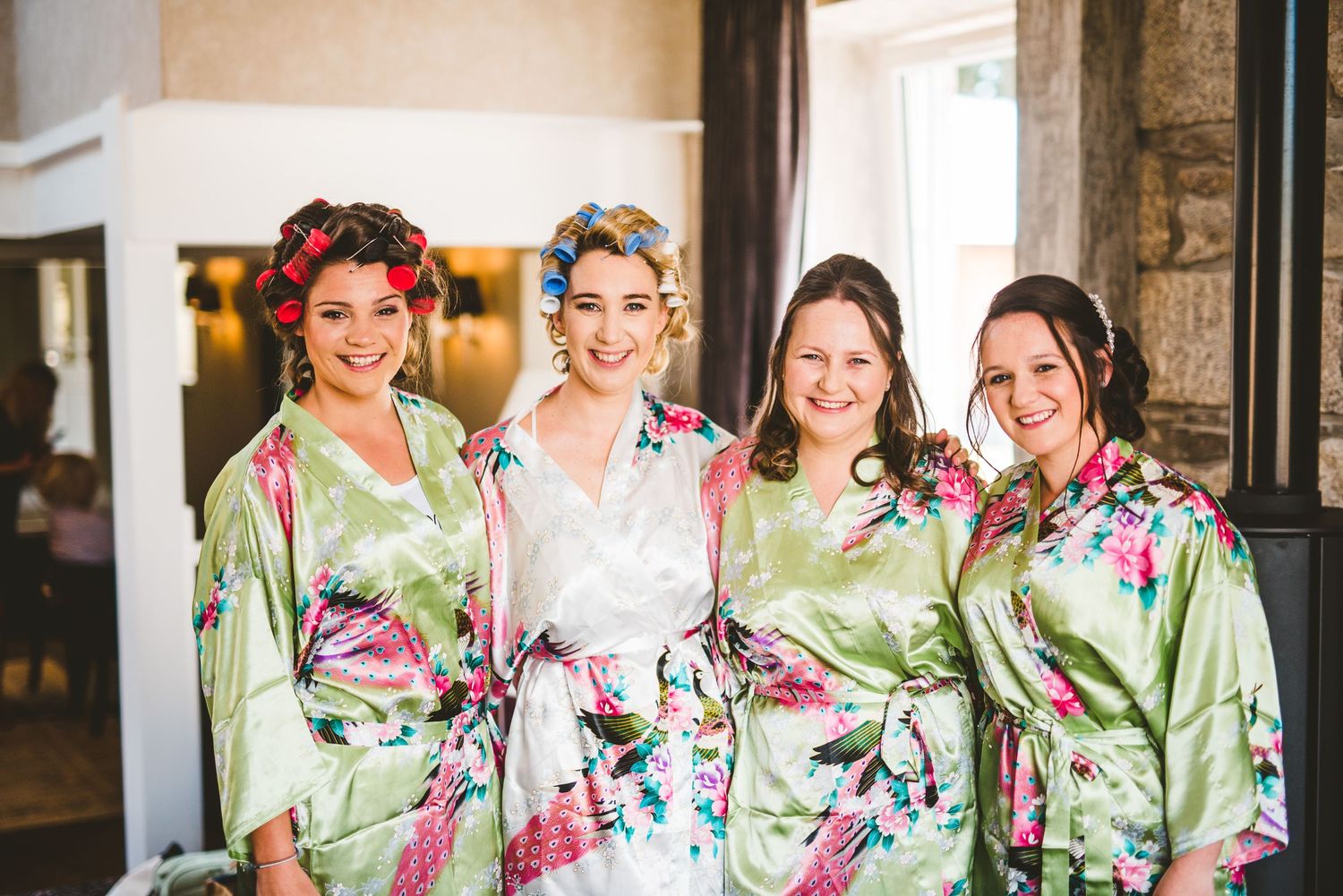 Group wearing matching floral robes standing together in a rustic setting.