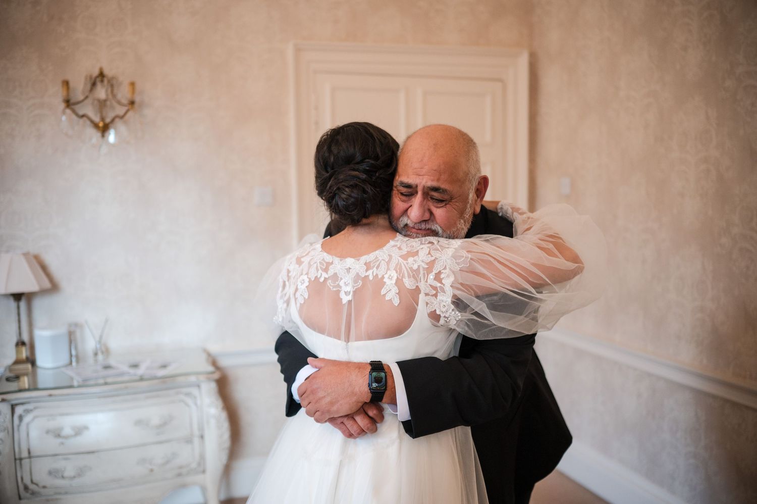 Aberdeen Wedding Photography. Emotional embrace captured during wedding celebration in elegant indoor setting.