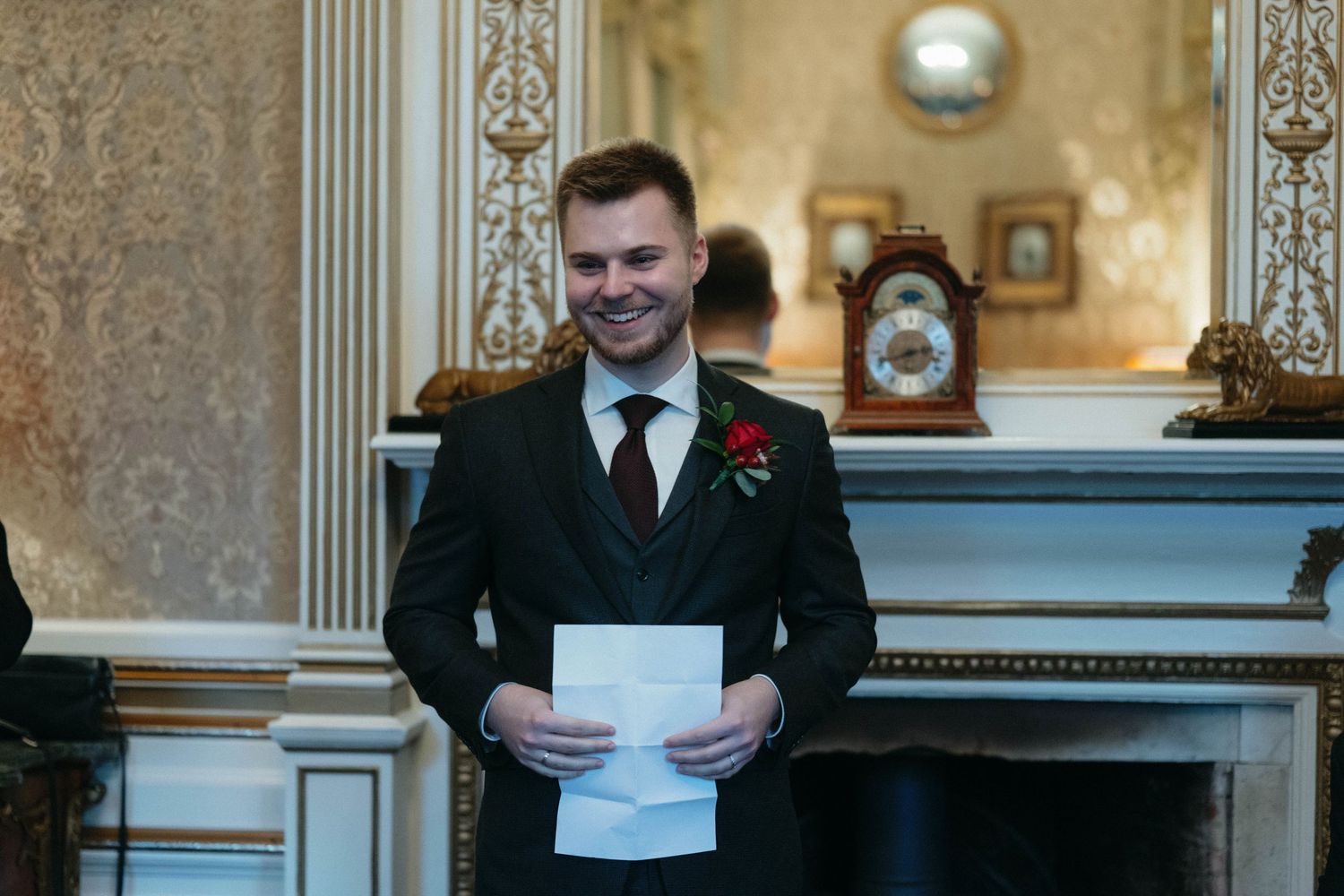 Formal event in an elegant room with ornate gold walls and white trim details.
