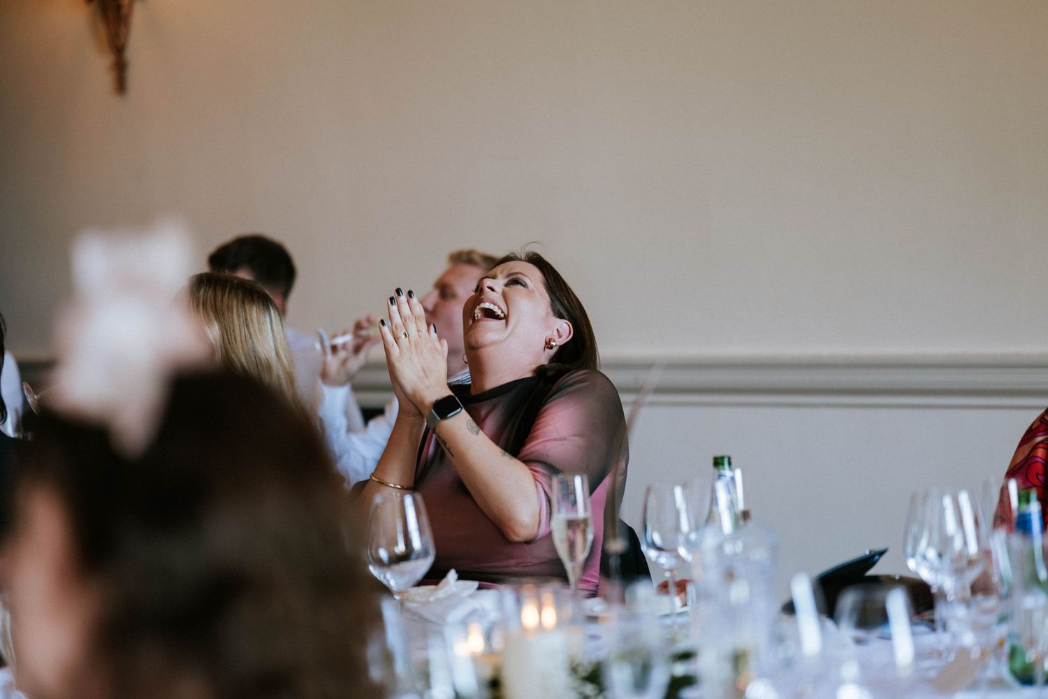 Wedding guest reacts with emotion during reception dinner celebrations.
