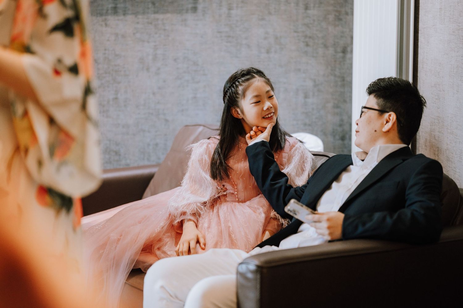 Couple sharing a joyful moment while sitting on a grey couch.