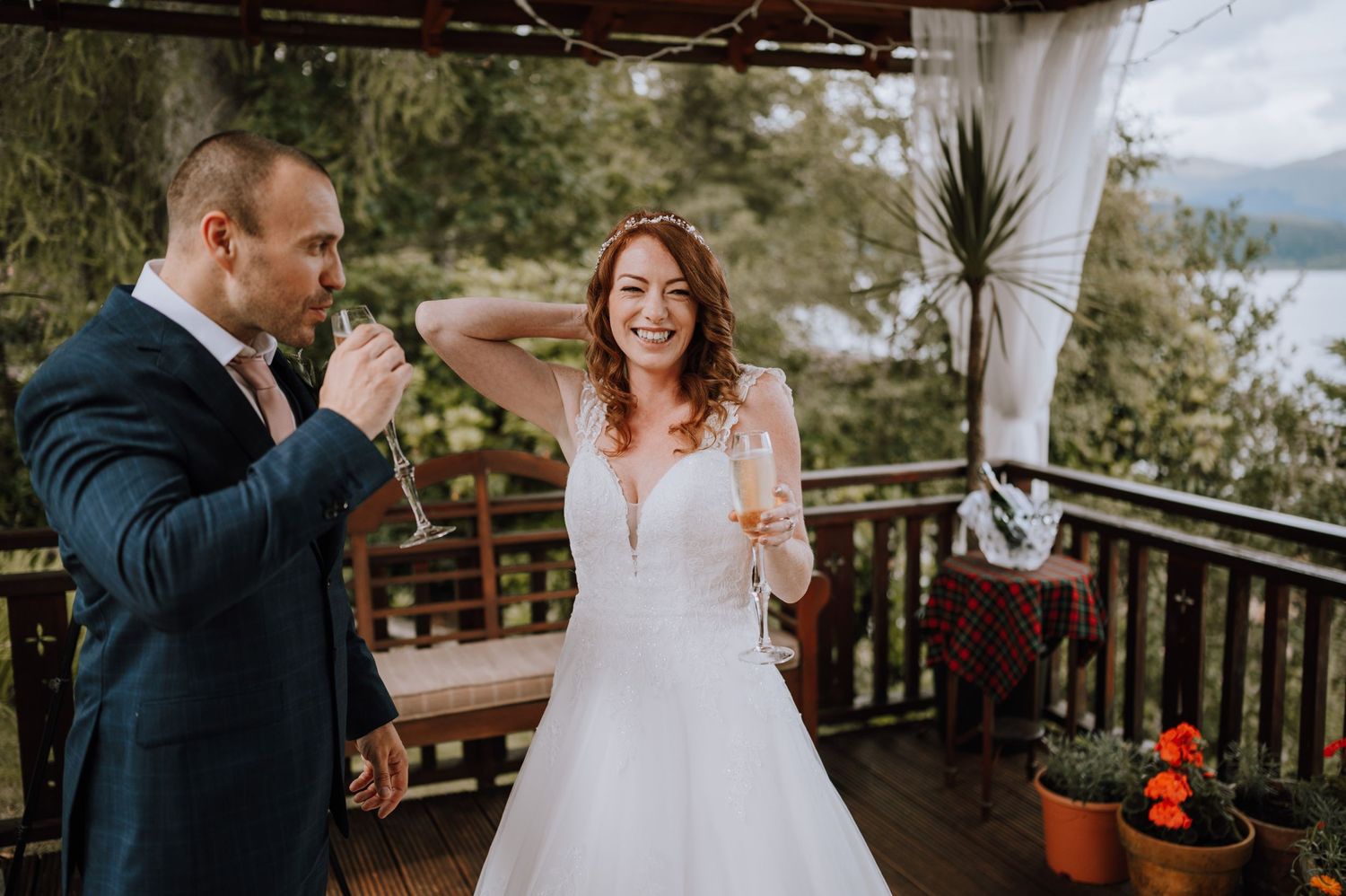 Joyful wedding celebration moment on a deck overlooking scenic mountain landscape.
