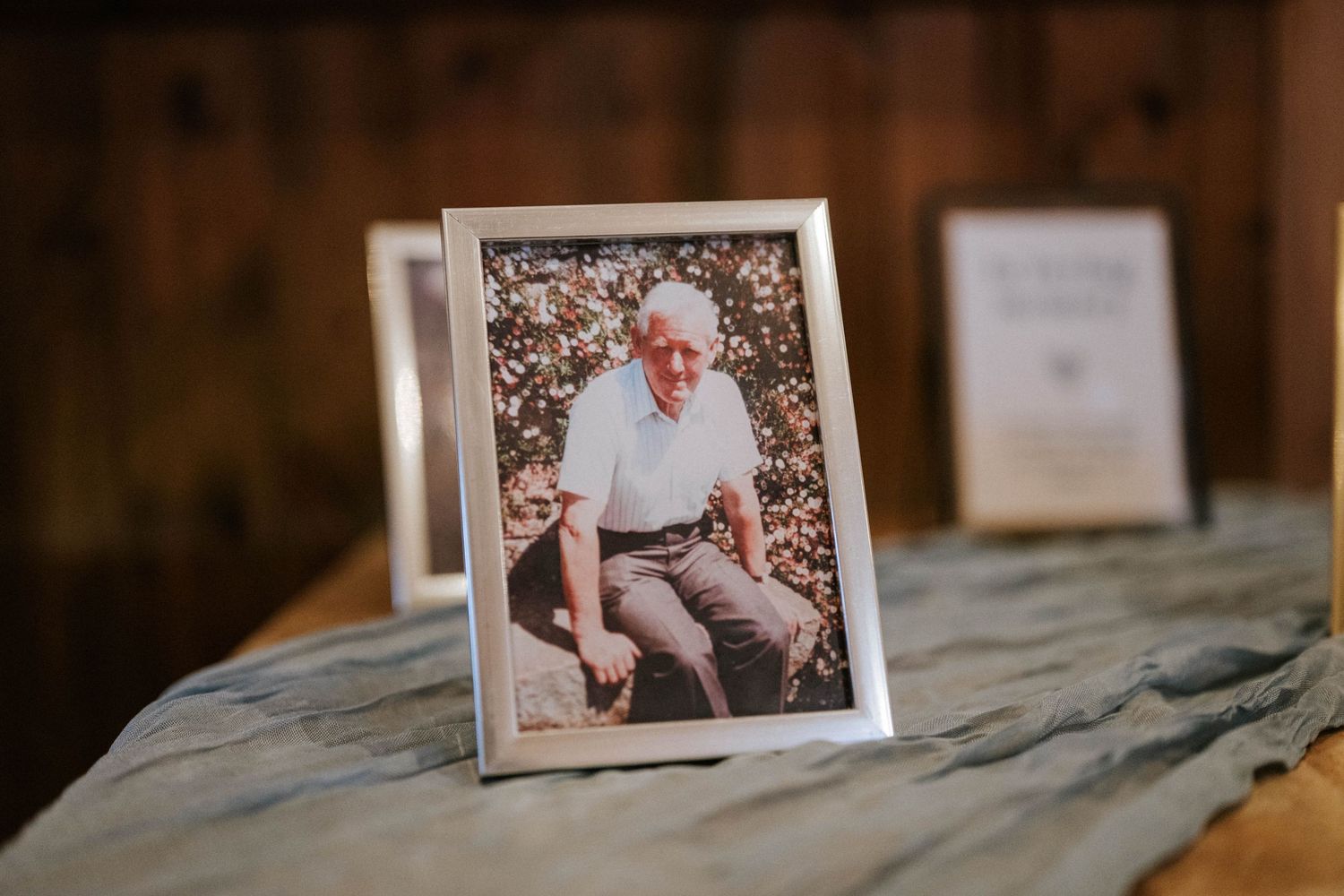 Vintage photographs displayed on rustic wooden surface in warm lighting.