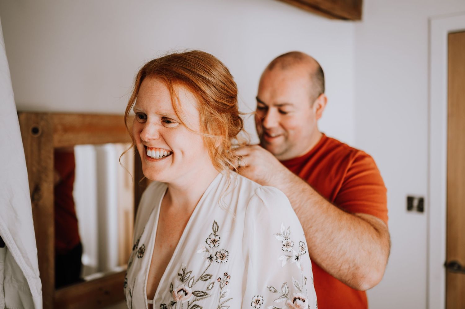 Two people sharing a candid moment while getting ready.
