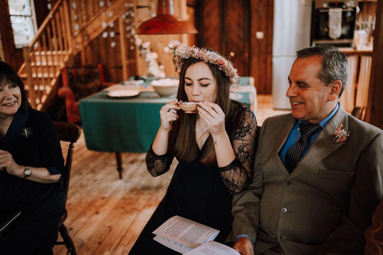 People sharing an emotional moment in a rustic room with wooden stairs and decor.