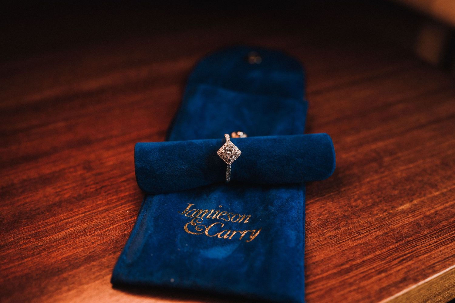 Diamond engagement ring nestled in a royal blue velvet jewelry pouch.