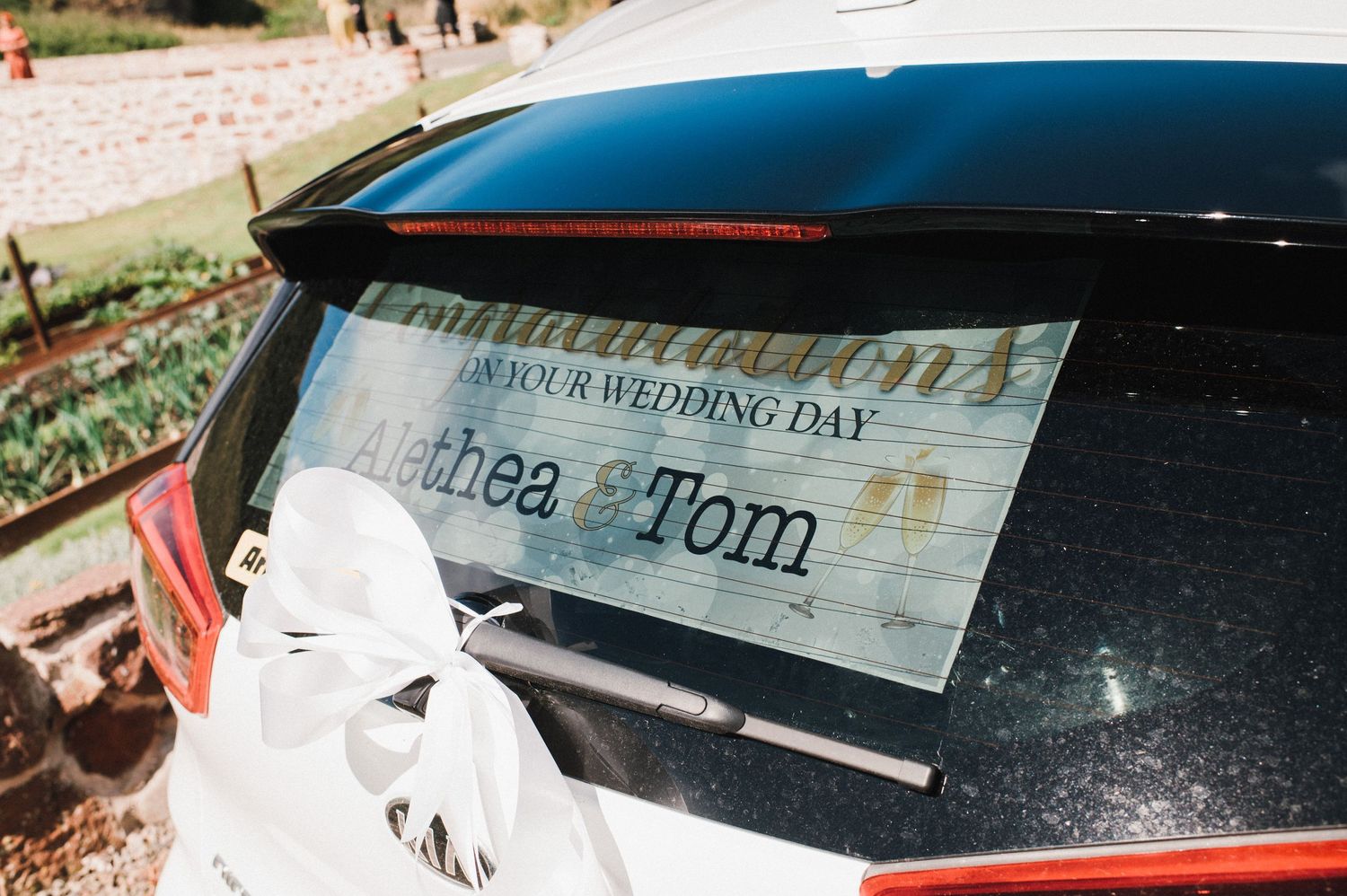 A wedding day sign displayed on the back window of a car.