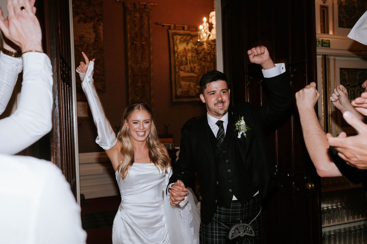 Wedding reception celebration with guests dancing in an elegant ballroom.