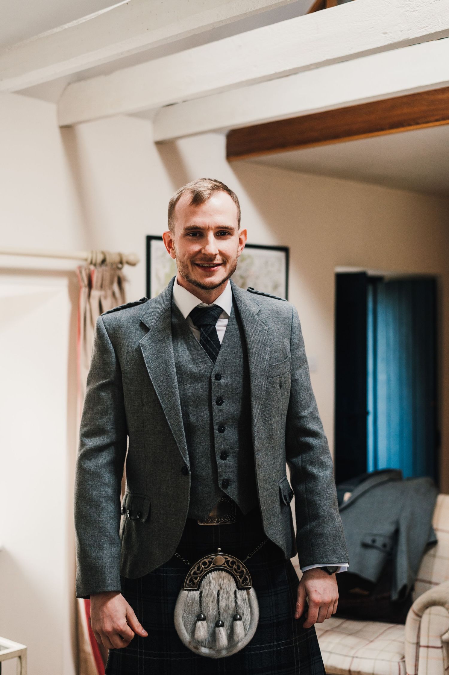 Scottish wedding attire featuring a grey tweed jacket and traditional sporran kilt accessory.