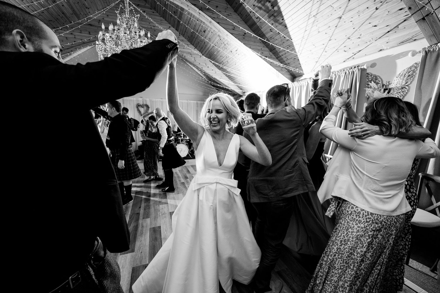 Aberdeen Wedding Photography. Wedding reception dance floor filled with celebrating guests under chandelier.