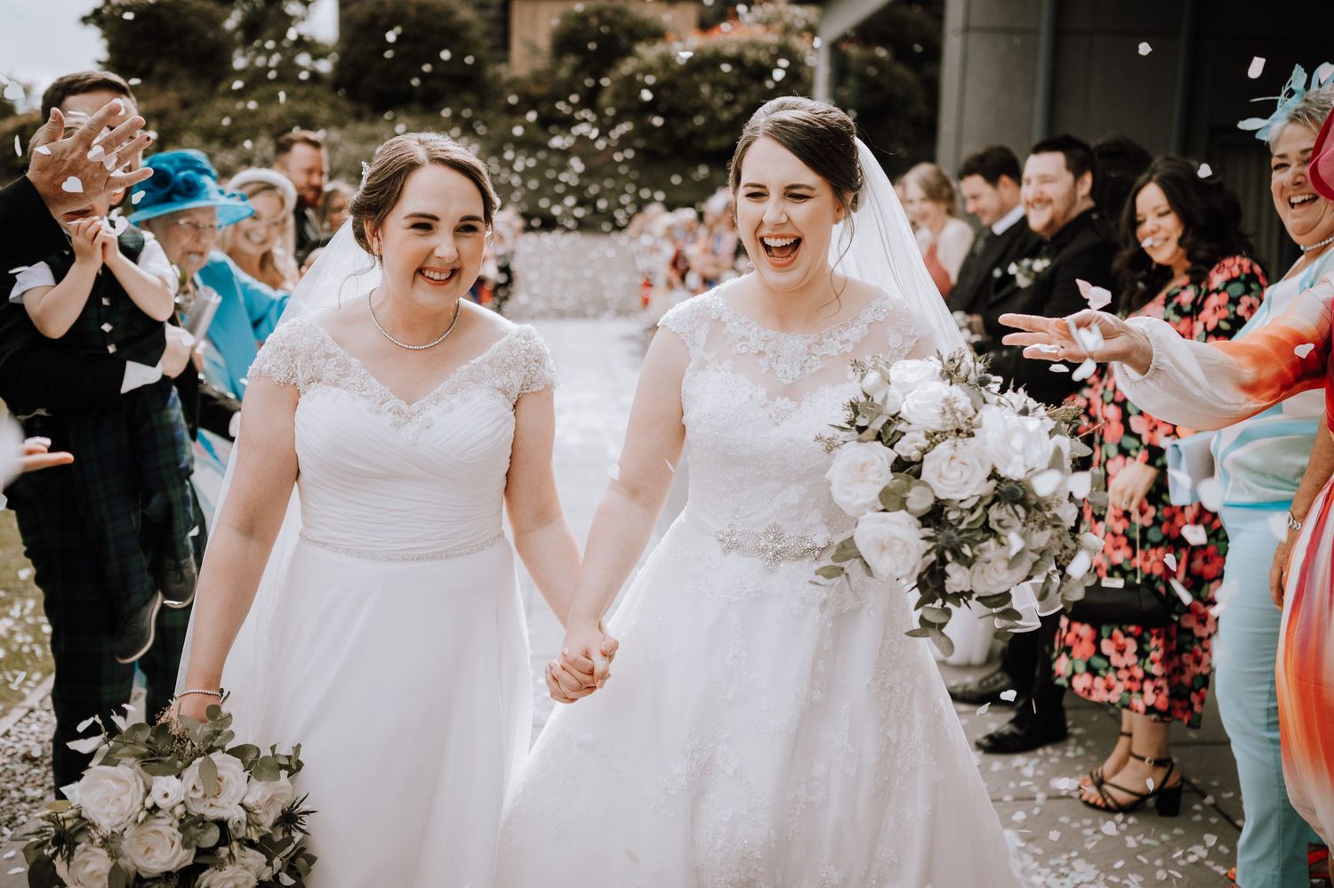Wedding guests celebrate during outdoor ceremony with colorful attire. Meldrum House Wedding Photography.