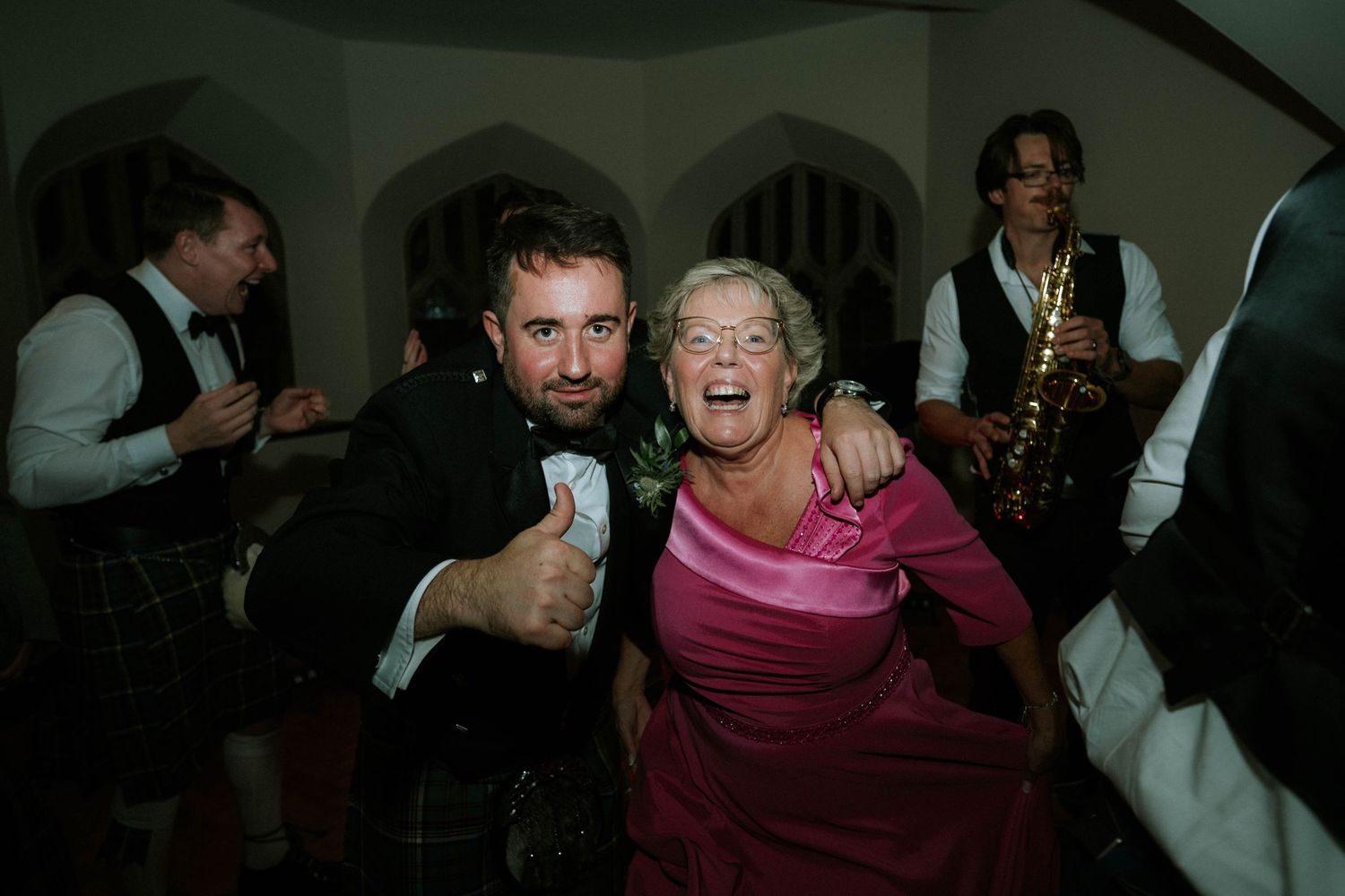 Wedding guests dancing and celebrating with high energy on the dance floor.