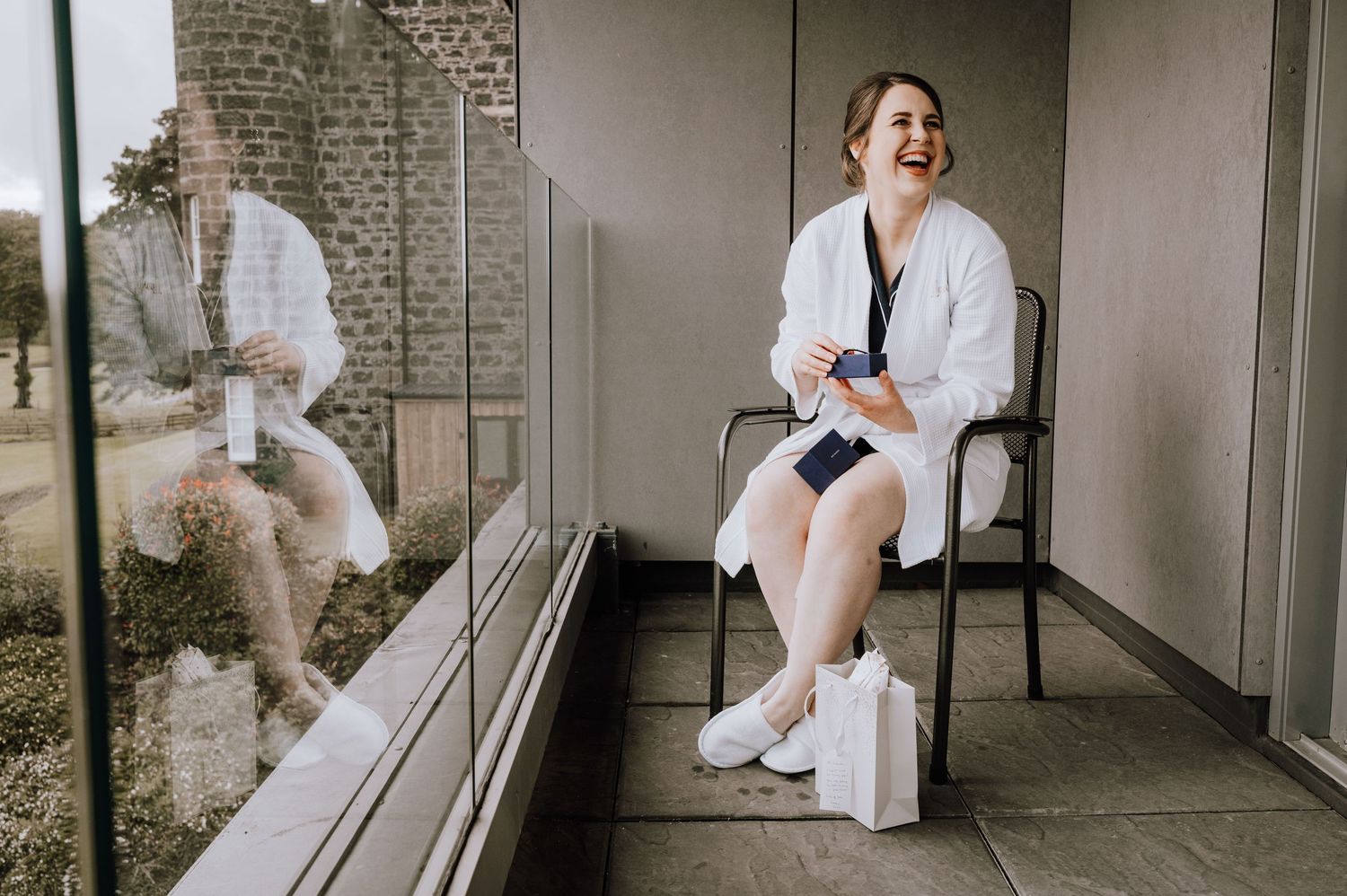 Wedding party members sharing joyful moments in a modern hallway. Meldrum House Wedding Photography.